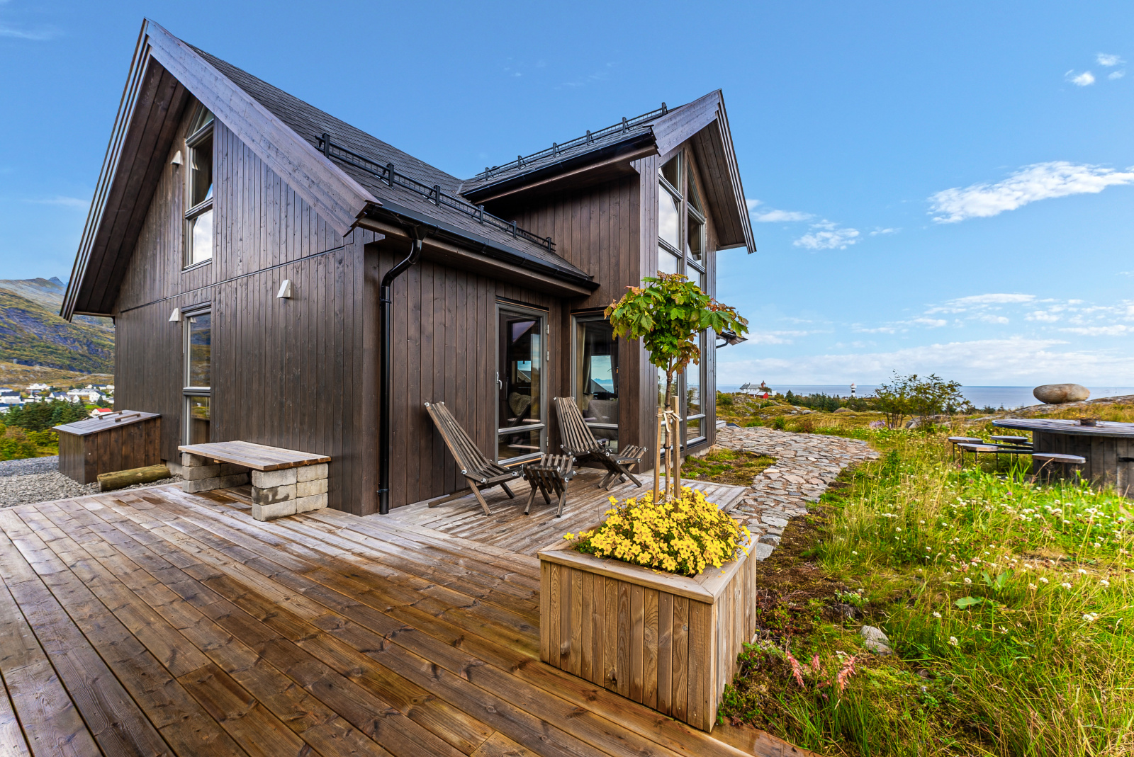 Hytta sett utenfra med terrasse og blomsterkasse