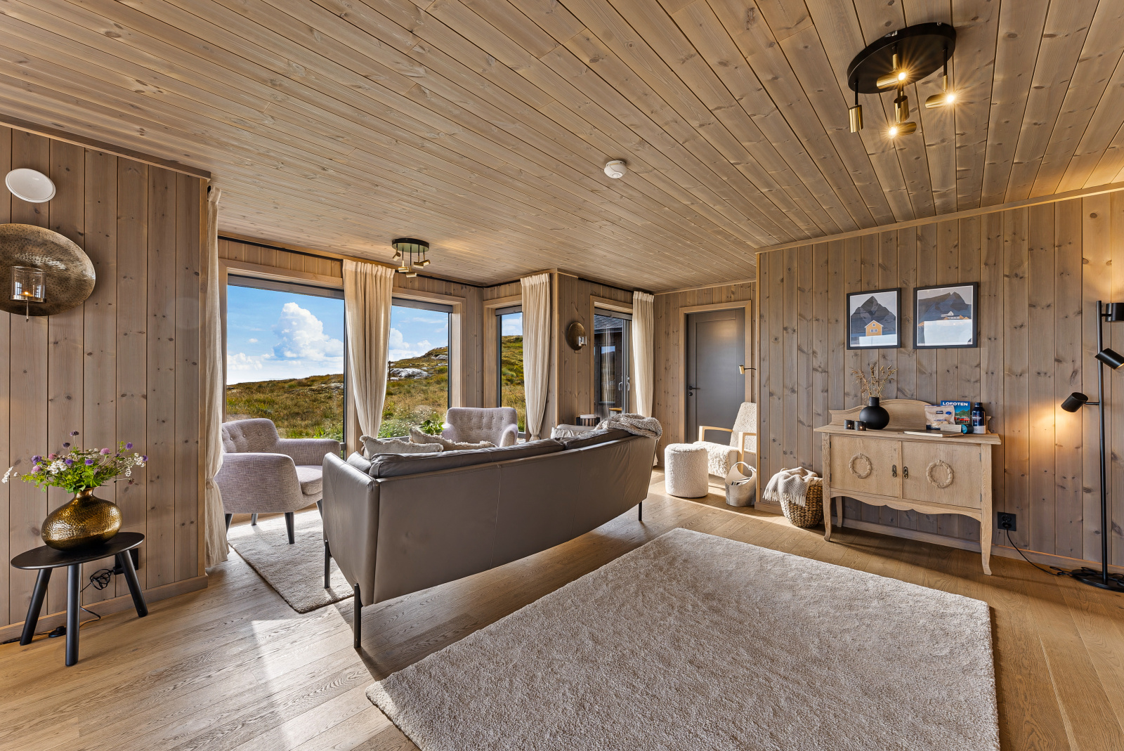 Stue med sofa, skjenk og innrammede bilder